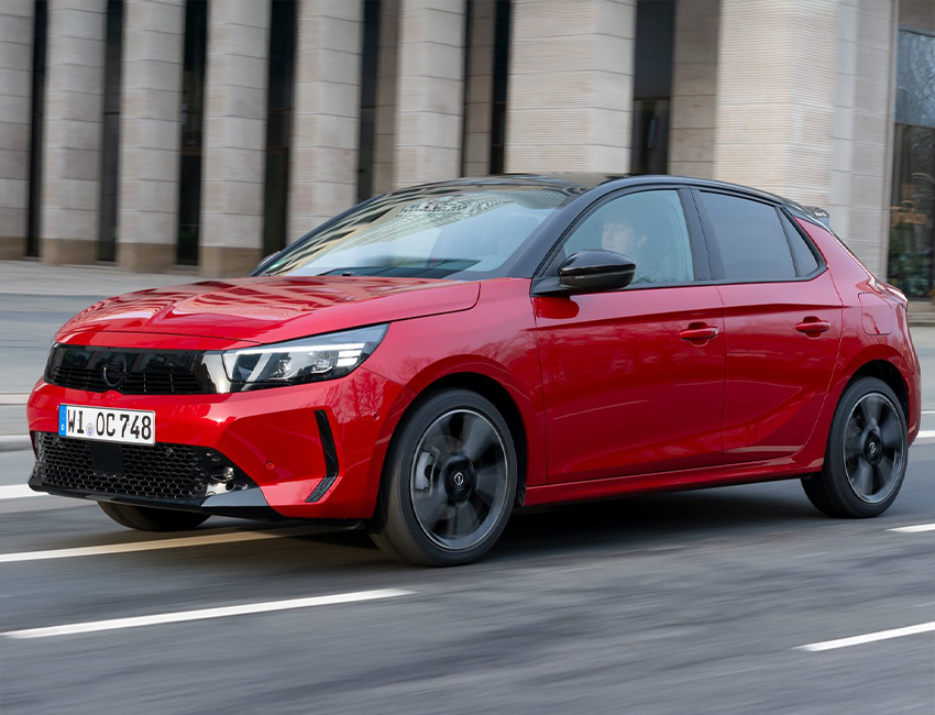 Vue avant de l’Opel Corsa garée devant un immeuble moderne